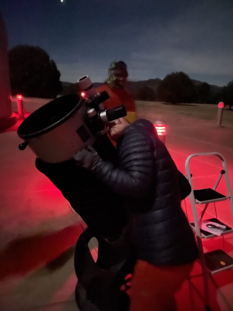 Woman looking through a telescope.