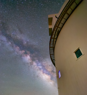 The Milky Way shines near a telescope building.