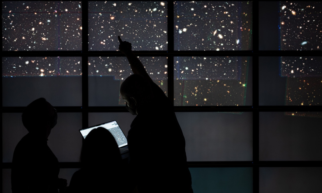Members of the CEERS collaboration explore the first wide, deep field image from the James Webb Space Telescope at the Texas Advanced Computing Center’s Visualization Lab on the UT Austin campus on July 21, 2022. Credit: Nolan Zunk/University of Texas at Austin.
