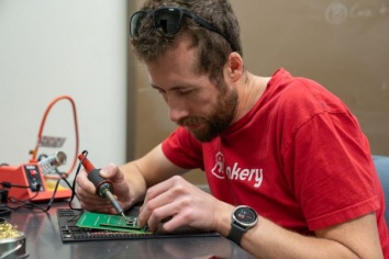Workshop participant building a handheld device.